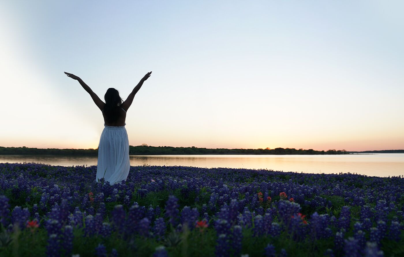 A woman standing in an open Texas wildflower meadow